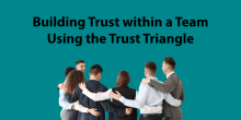 Graphic with the words "Building trust within a team using the trust triangle" on a blue background. Below the text, a group of people gather in a huddle.